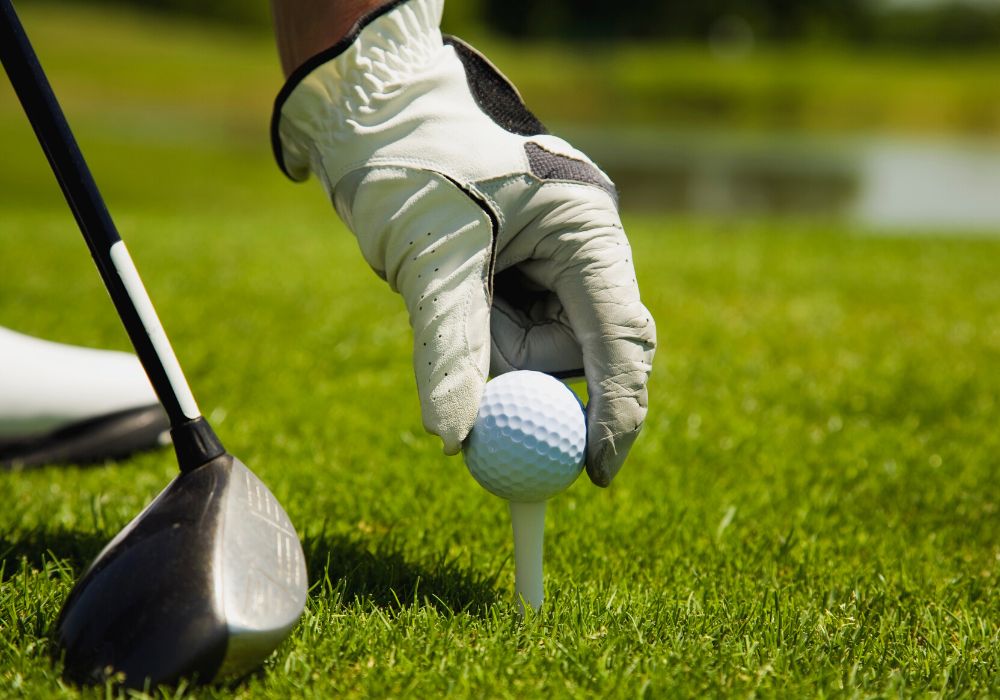 A golfer inspects his golf ball with a close-up of his putt.