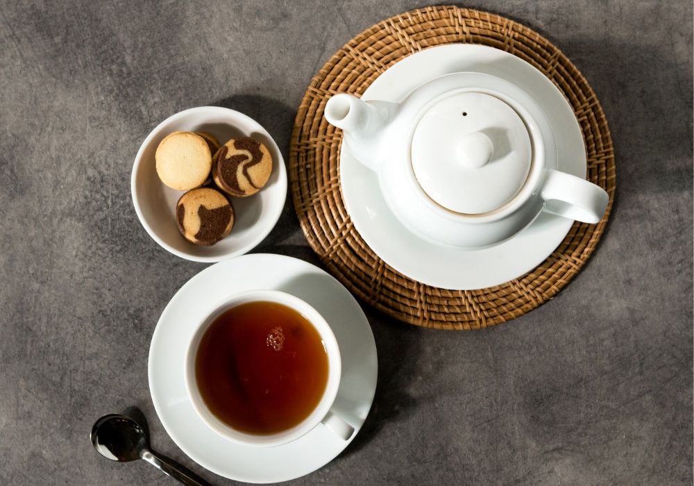 English tea in a white porcelain tea cup and tea pot for afternoon tea.