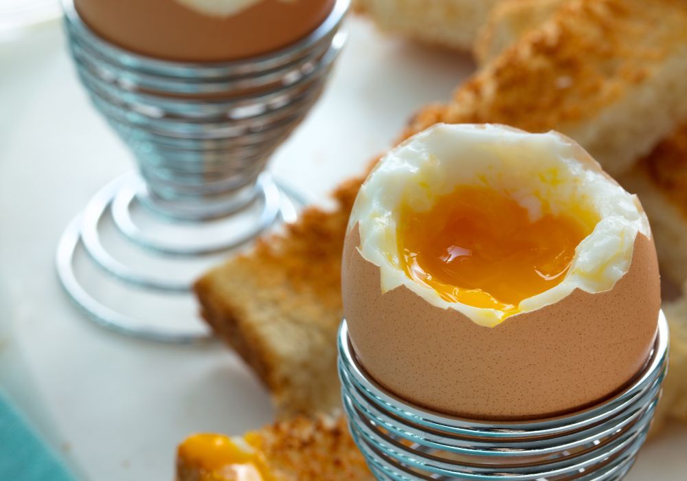 Soft boiled eggs and soldier toast were served on the table.