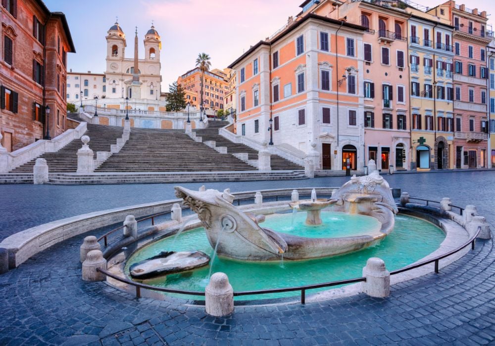 Cityscape image of Spanish Steps and Barcaccia Fountain in Rome, Italy during sunrise.