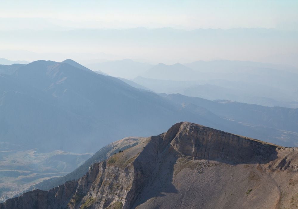 Sharp ridge atop mountain set against a fog mist rich background of valleys in Tomorr, Albania