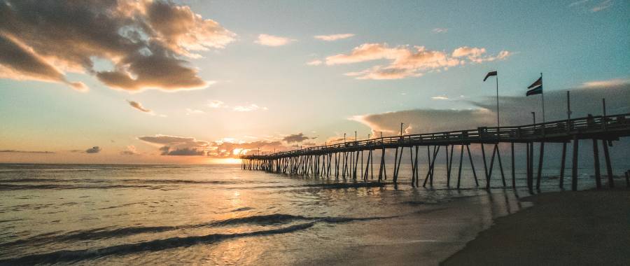 Outer Banks, NC at sunrise with pier in the horizon