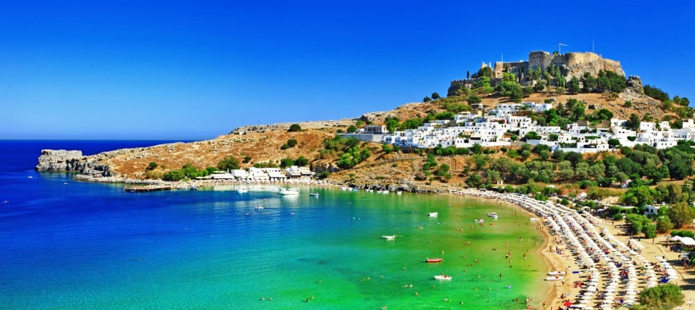 The village and Acropolis above Lindos Beach, Rhodes, one of the most beautiful beaches in Greece