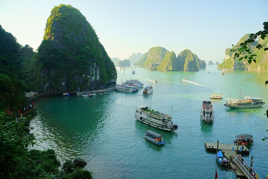 Boats and tall cliff-islands in Halong Bay, one of the best places to visit in Vietnam