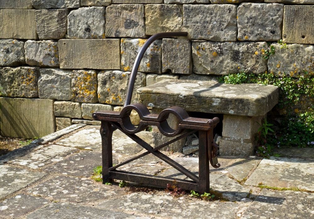 Old stocks outside the churchyard in Painswick, UK.