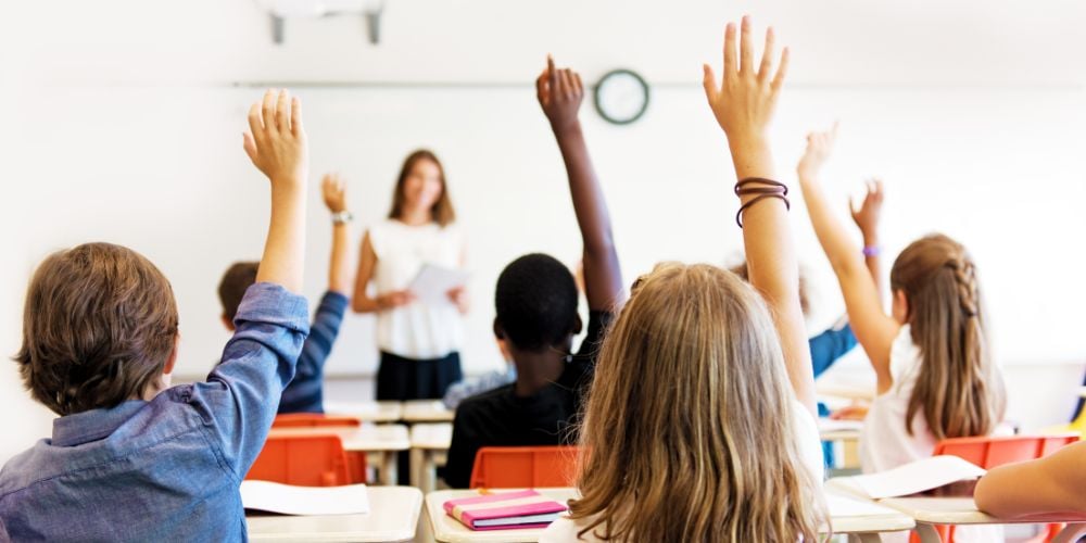 Children raising their hands in a classroom