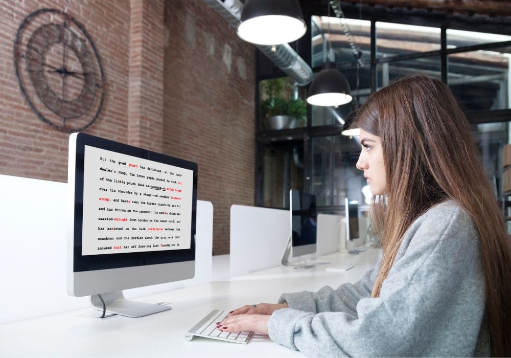 A young woman is proofreading and editing on her computer.