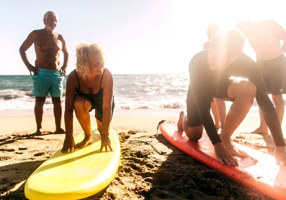 Photo of couple of senior people still willing to learn and to try new things, like surfing.