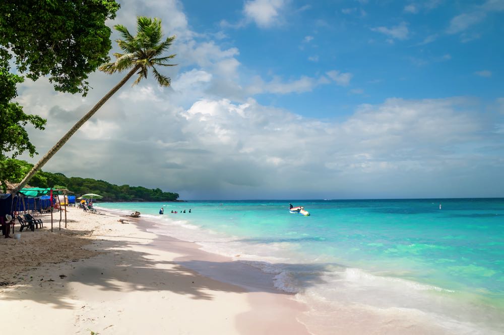 Palm tree, white sand and turquoise water at Playa Blanca, Cartagena