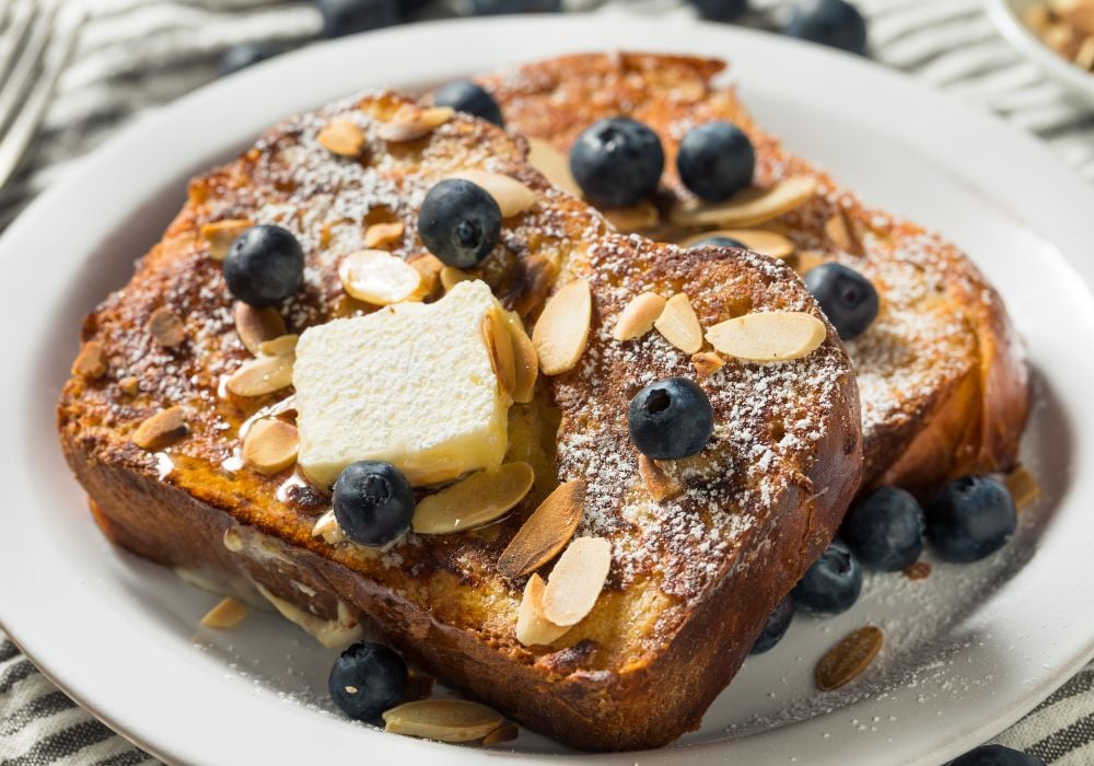 French brioche toast with berries on a white plate