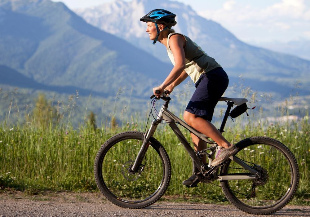 A woman mountain biking along a scenic trail