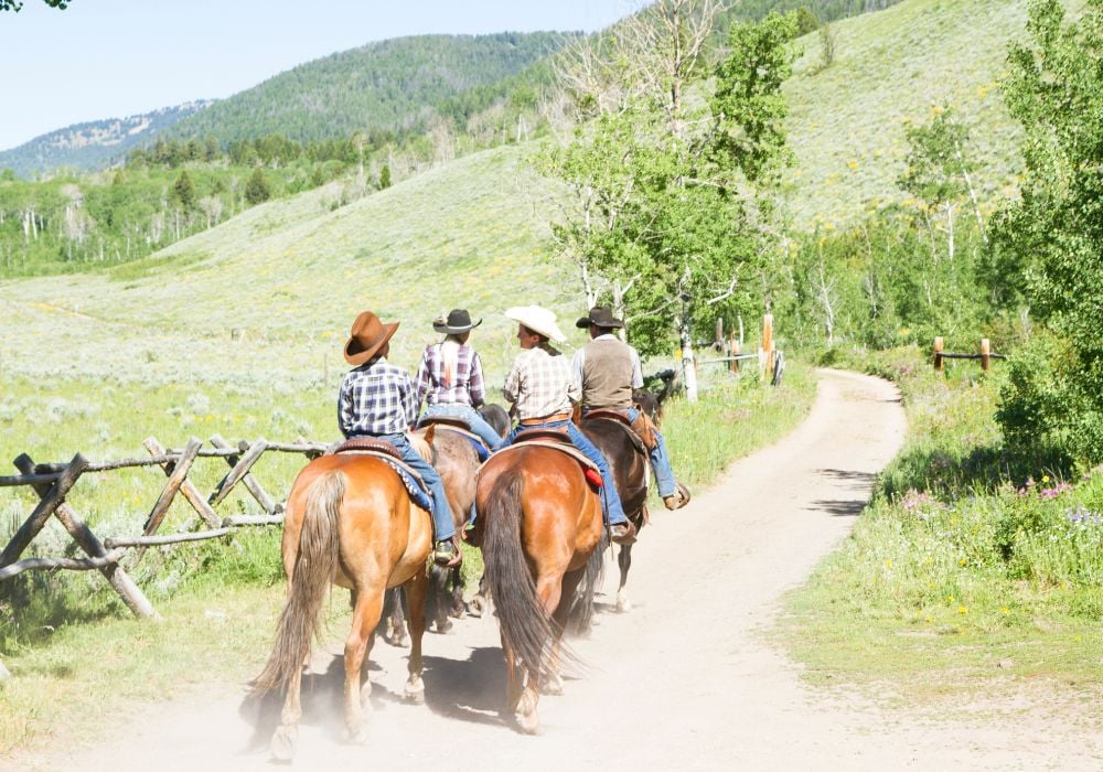 A family rides horses across the terrain in Montana.