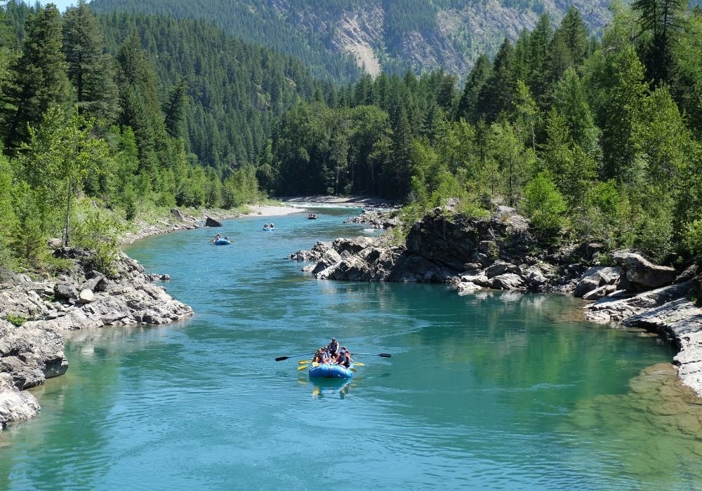 A group of adventurers is doing whitewater rafting along the Emerald Lake in the Gallatin River, Montana.