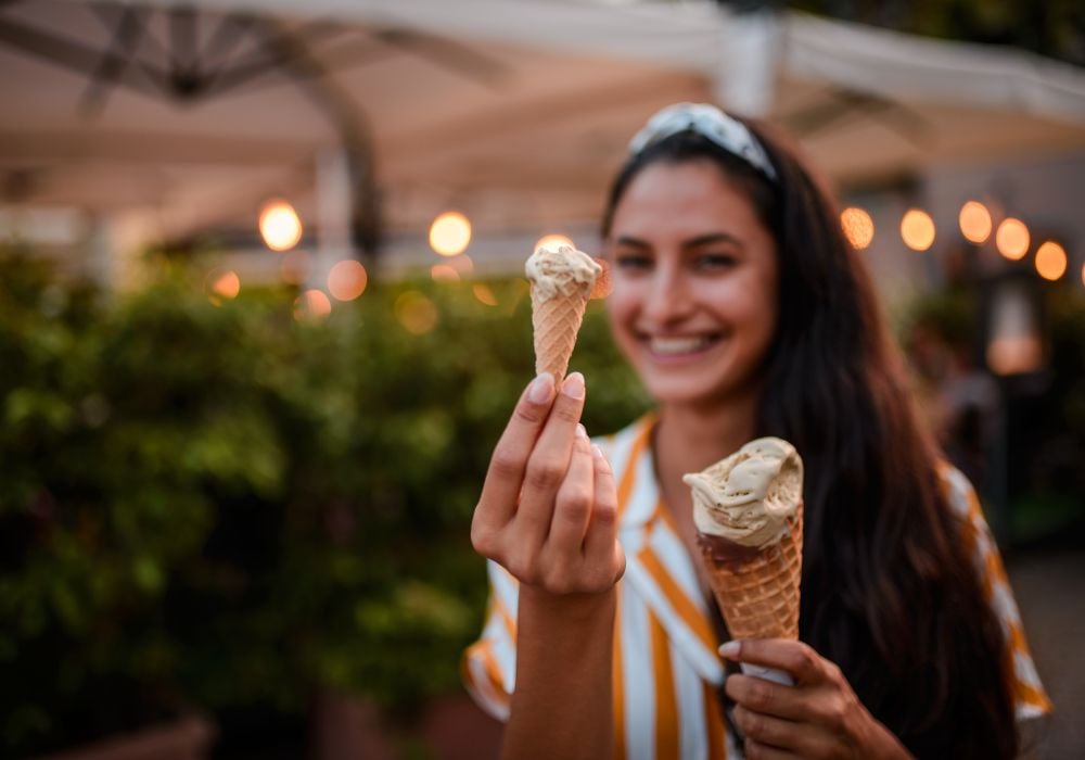 Happy smiling woman holding two Puglian gelato in Italy