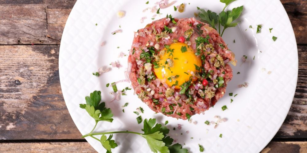 A traditional steak tartare with an egg on top
