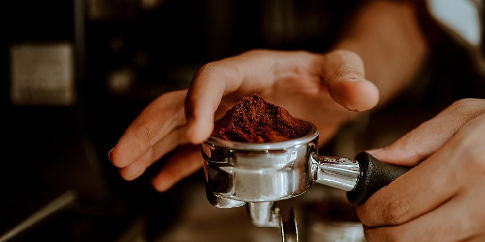 Preparing coffee grounds to make fresh espresso