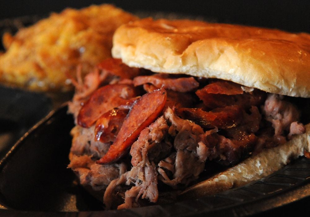 The brisket sandwich is topped with a pork hot link and served with peach cobbler
