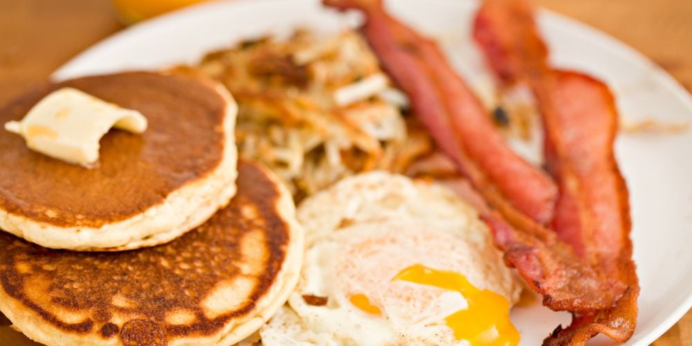 Breakfast of pancakes, eggs, and bacon