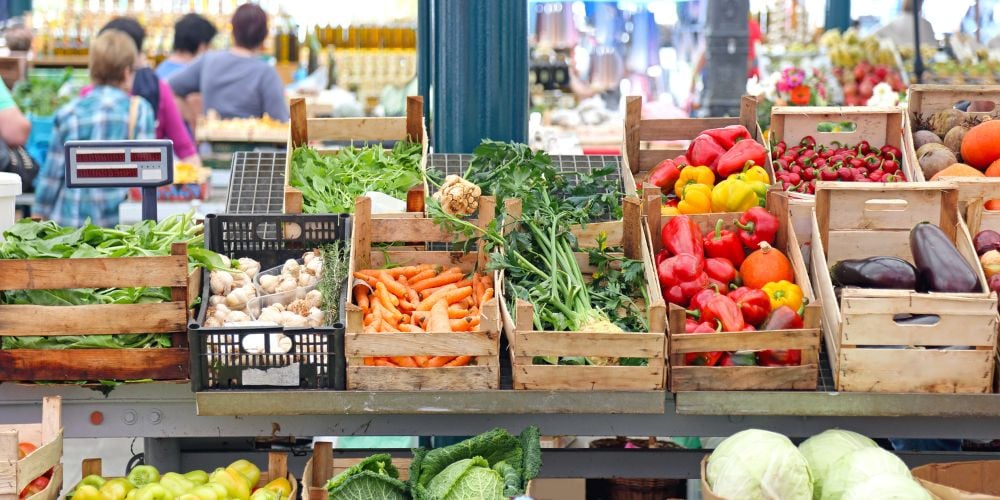 vegetables for sale at stalls in a farmer's market