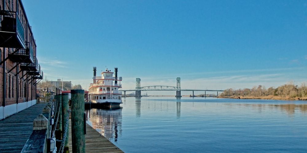 boat moored on cape fear river in north carolina with a bridge in the background