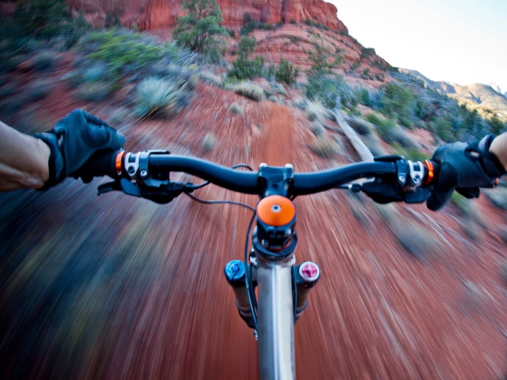 man riding a mountain bike downhill in the desert arizona