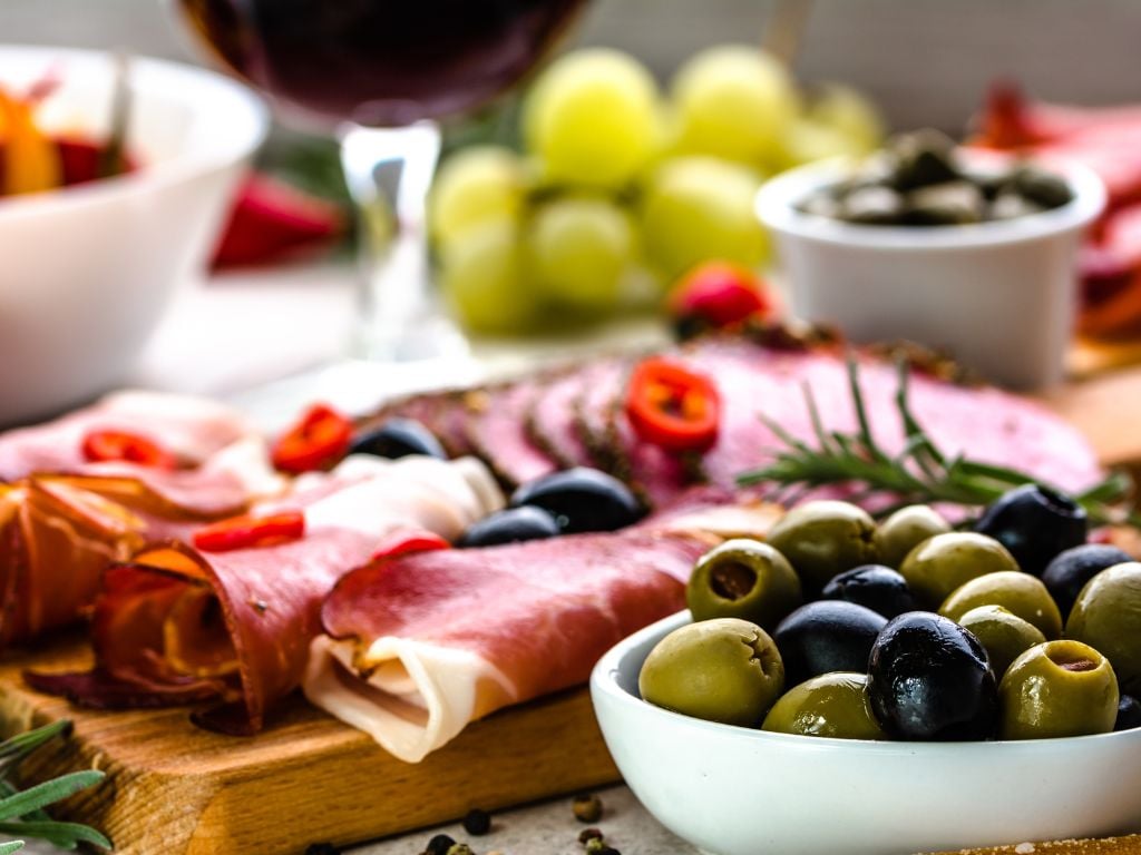 a platter of meats and olives