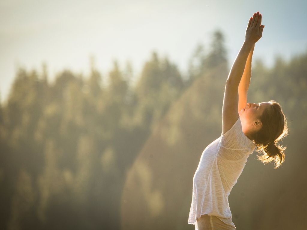 woman doing yoga with her arms reaching up