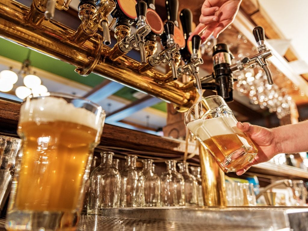 beer being poured from a tap at a bar