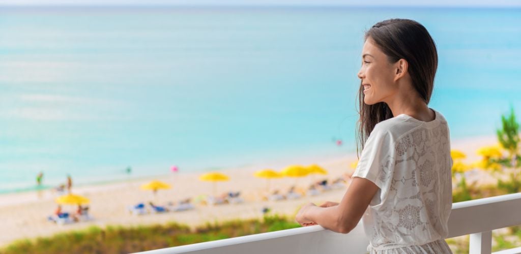 Beach view with a woman looking outside the balcony