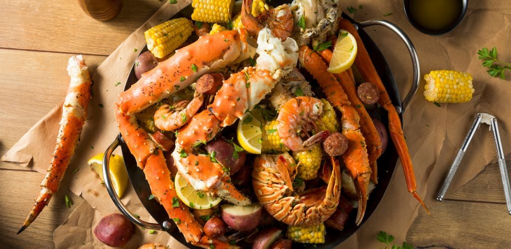 Seafoods composed of shrimps and crabs with corn, herbs and lemons
