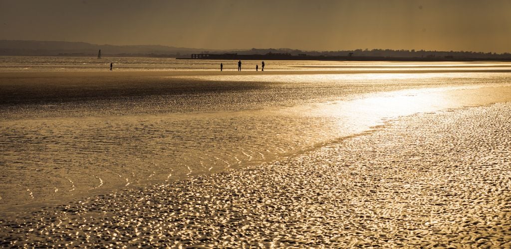 Camber Sands Beach with few people silhouette while sunset