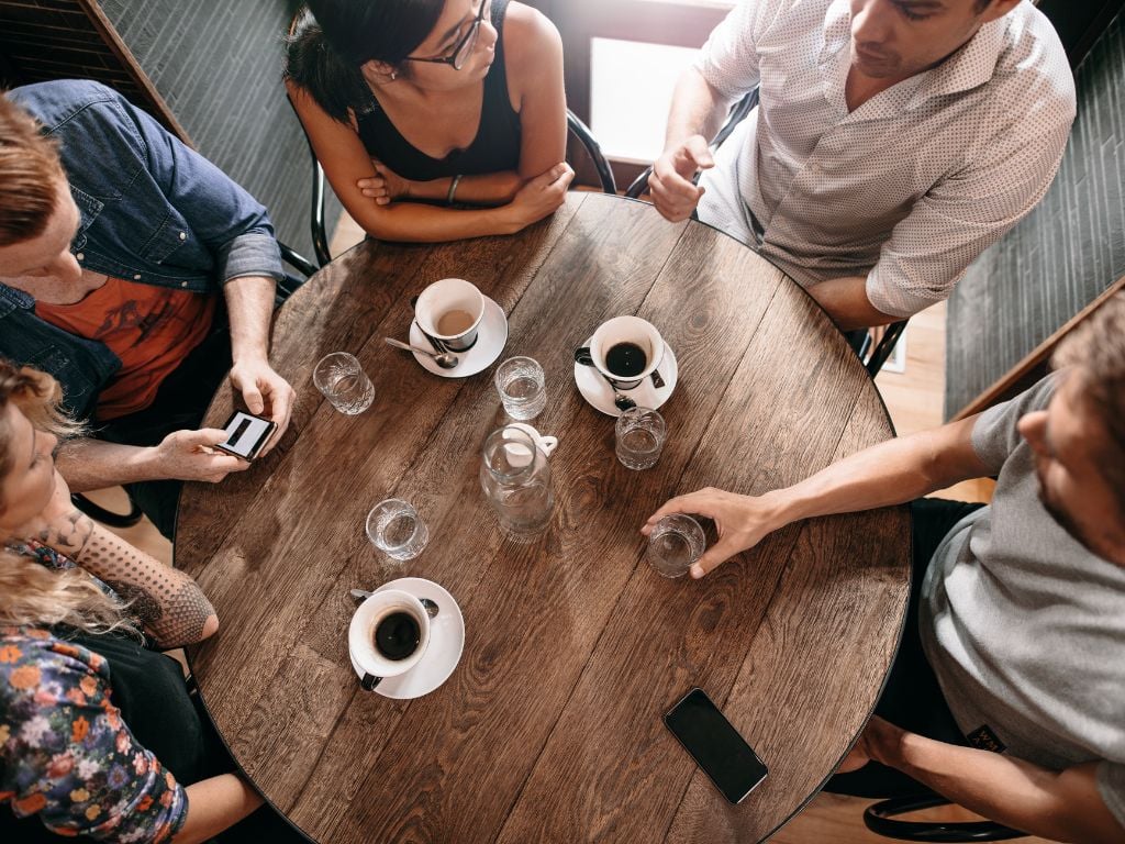 5 friends around a table with coffee