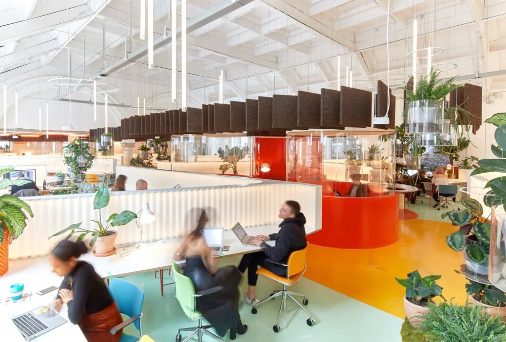 people at a coworking space in london with plants and laptops