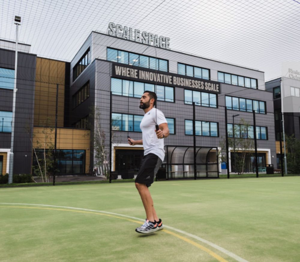 man jumping rope outside of a coworking space in london