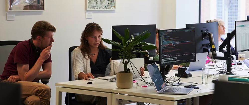 two people working at laptops at a coworking space