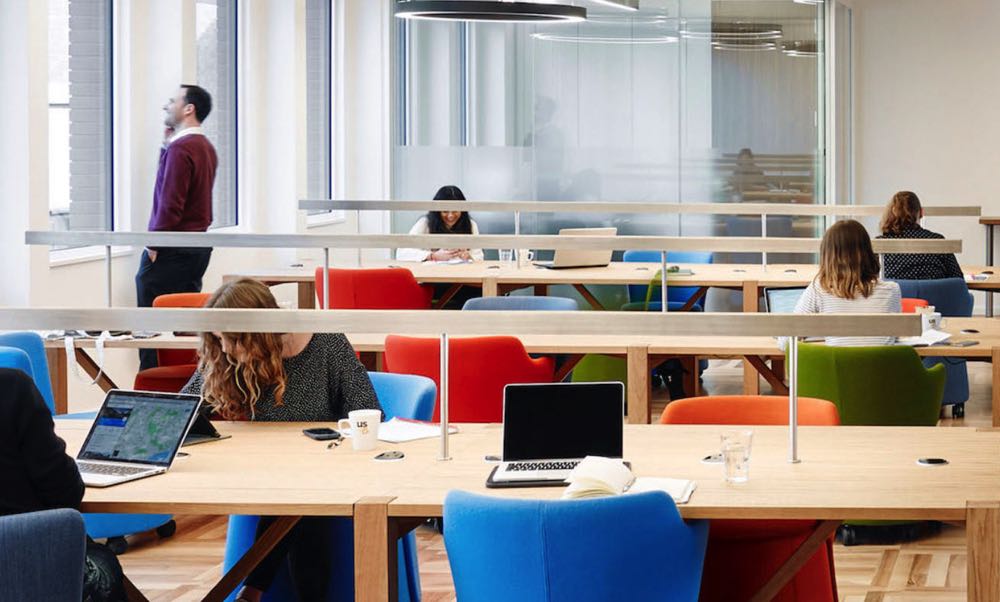 people coworking with colourful chairs and laptops