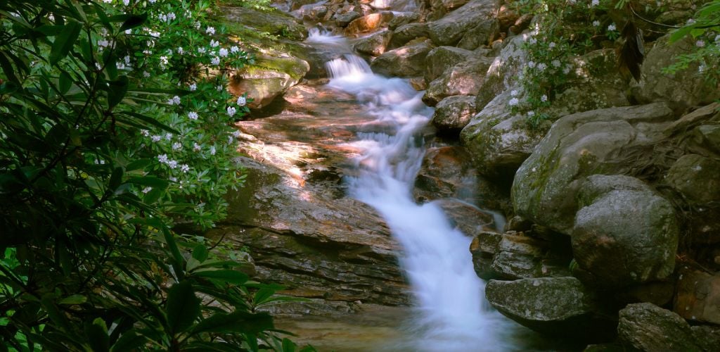Motion blurred water cascading down Skinny Dip Waterfall in North Carolina