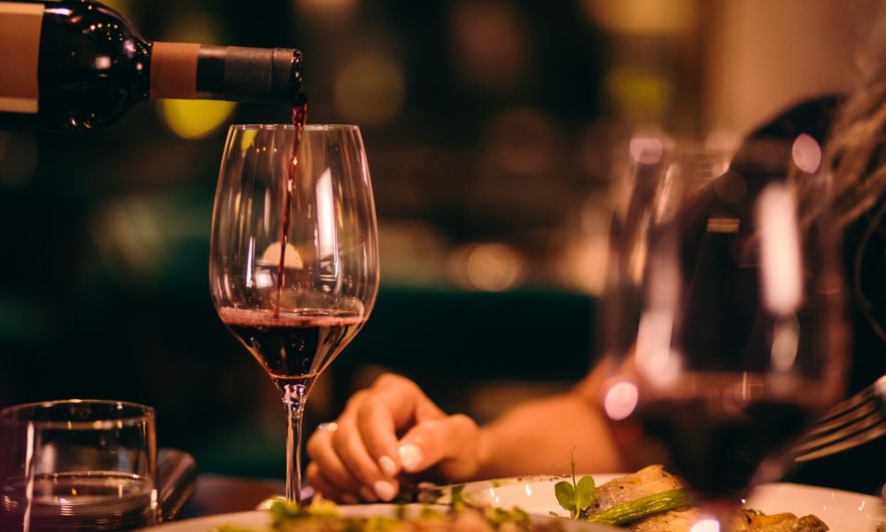 A wine being poured in a dinner table