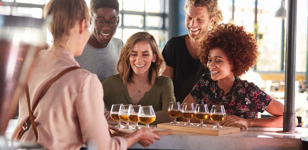 A group of people tasting drinks 