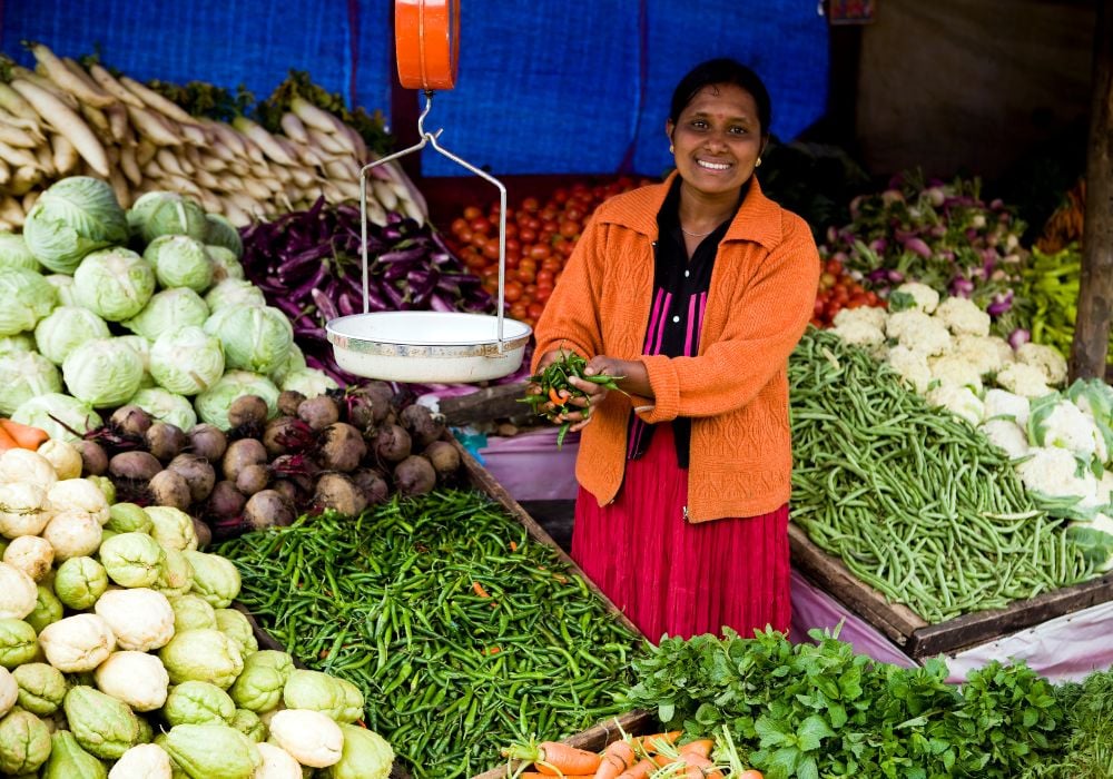 woman in sri lanka smiling and selling fruits and vegetables