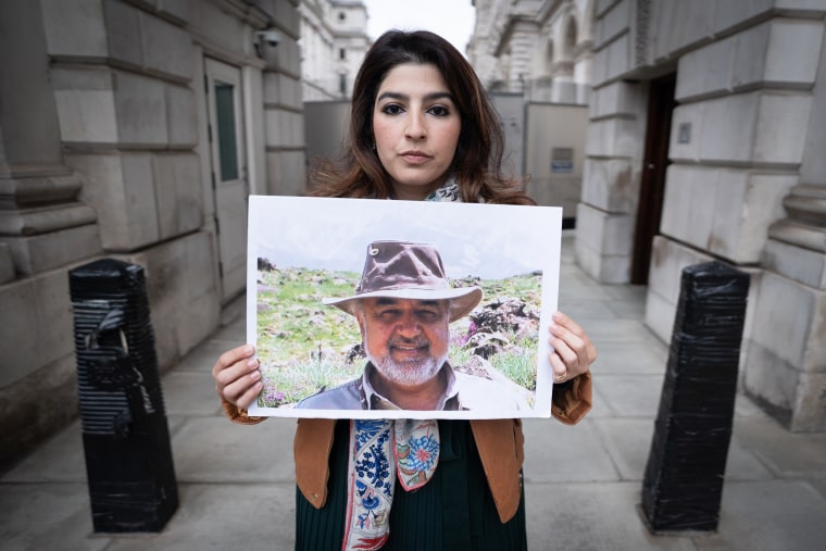 Roxanne Tahbaz holds a picture of her father Morad Tahbaz during a protest