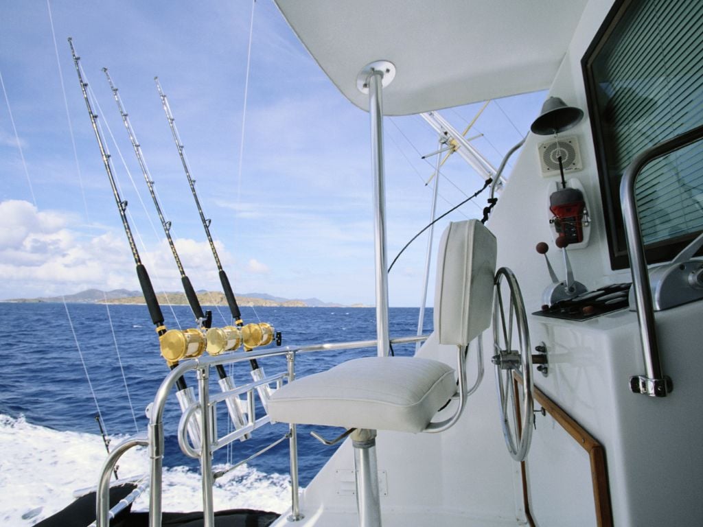 deep sea fishing with fishing rods and a white boat