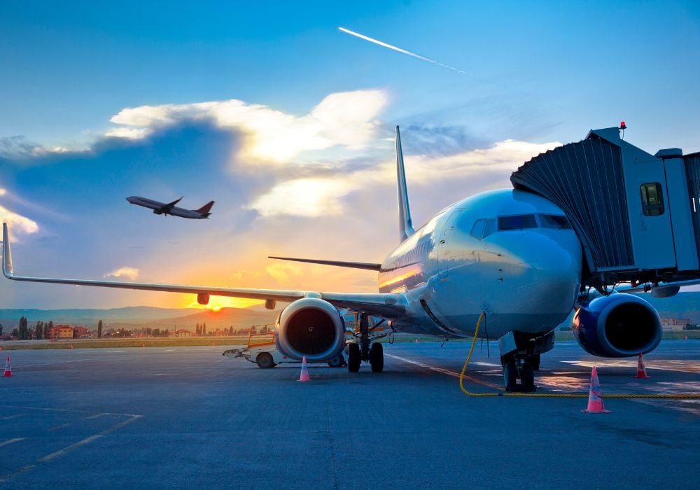 airport with a plane fueling up and one taking off