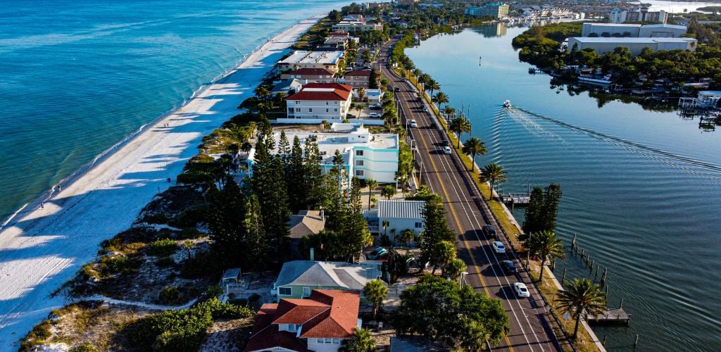 Indian Rocks Beach - aerial view of the resort with water bodies in the left and right side and buildings beside a highway 