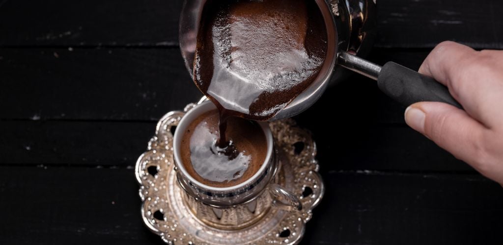 Turkish coffee being poured in a coffecup