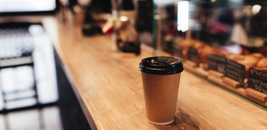 A cup of hot coffee on the counter table. 