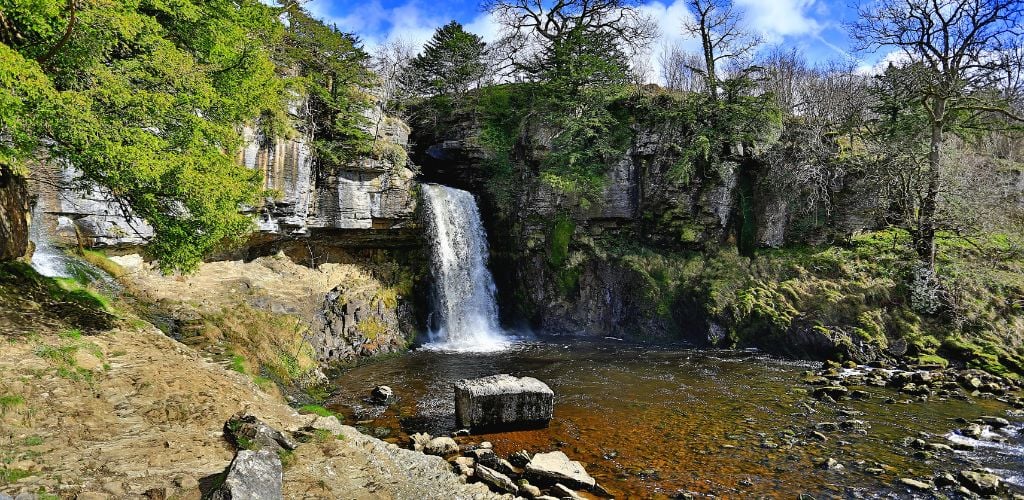 Ingleton Waterfalls Trail (Yorkshire Dales National Park) Water falls from the huge rocks beneath the ground with trees along the rocks