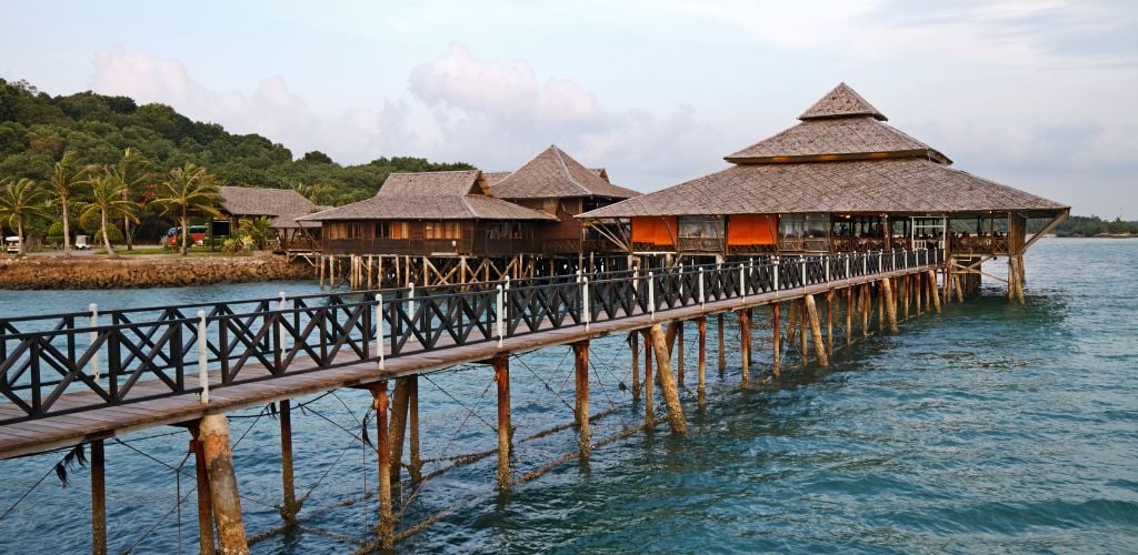 Floating Restaurant with foot bridge and palm trees in background.