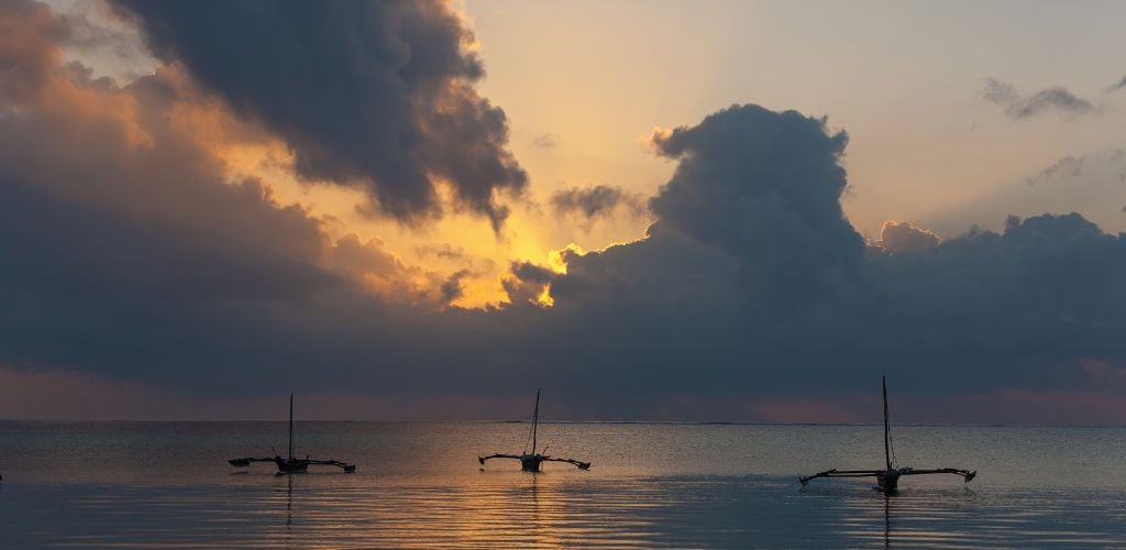 Sunset view of Indian ocean in Mombasa with 3 boats.