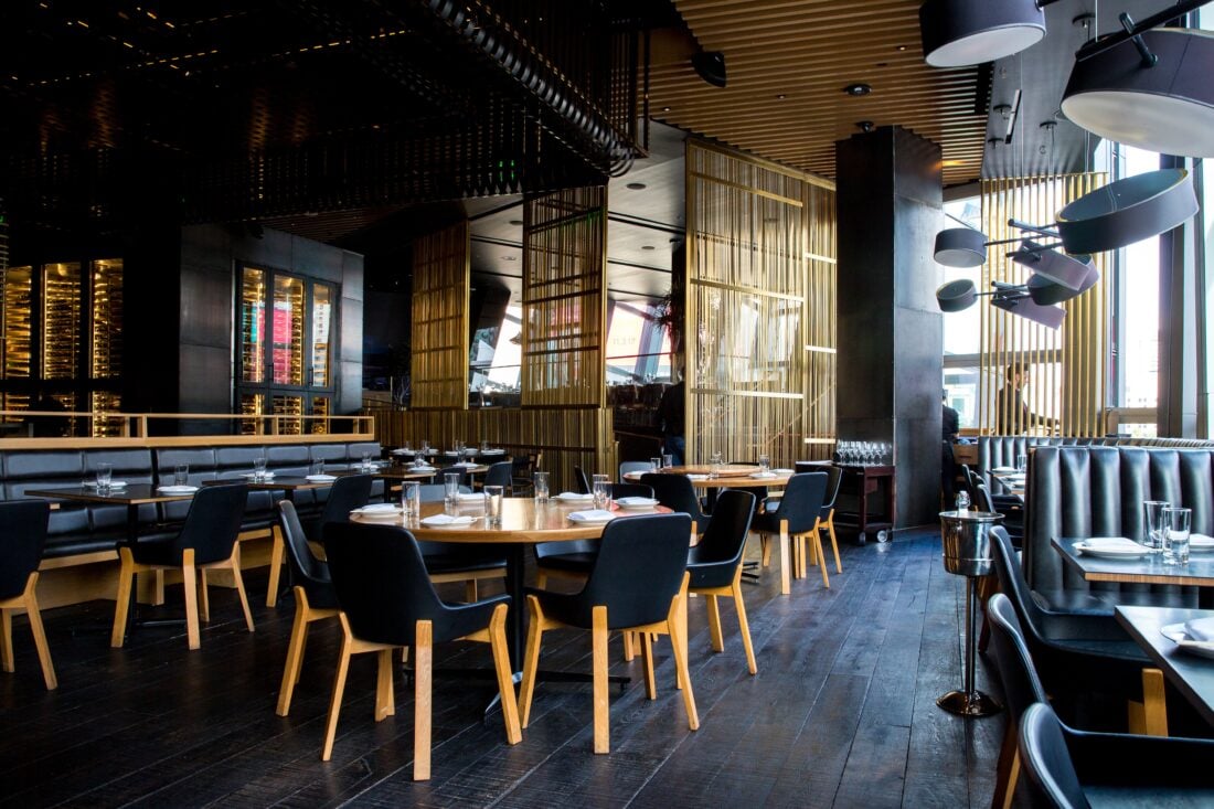 Black and bamboo styled restaurant with black booths and chairs.